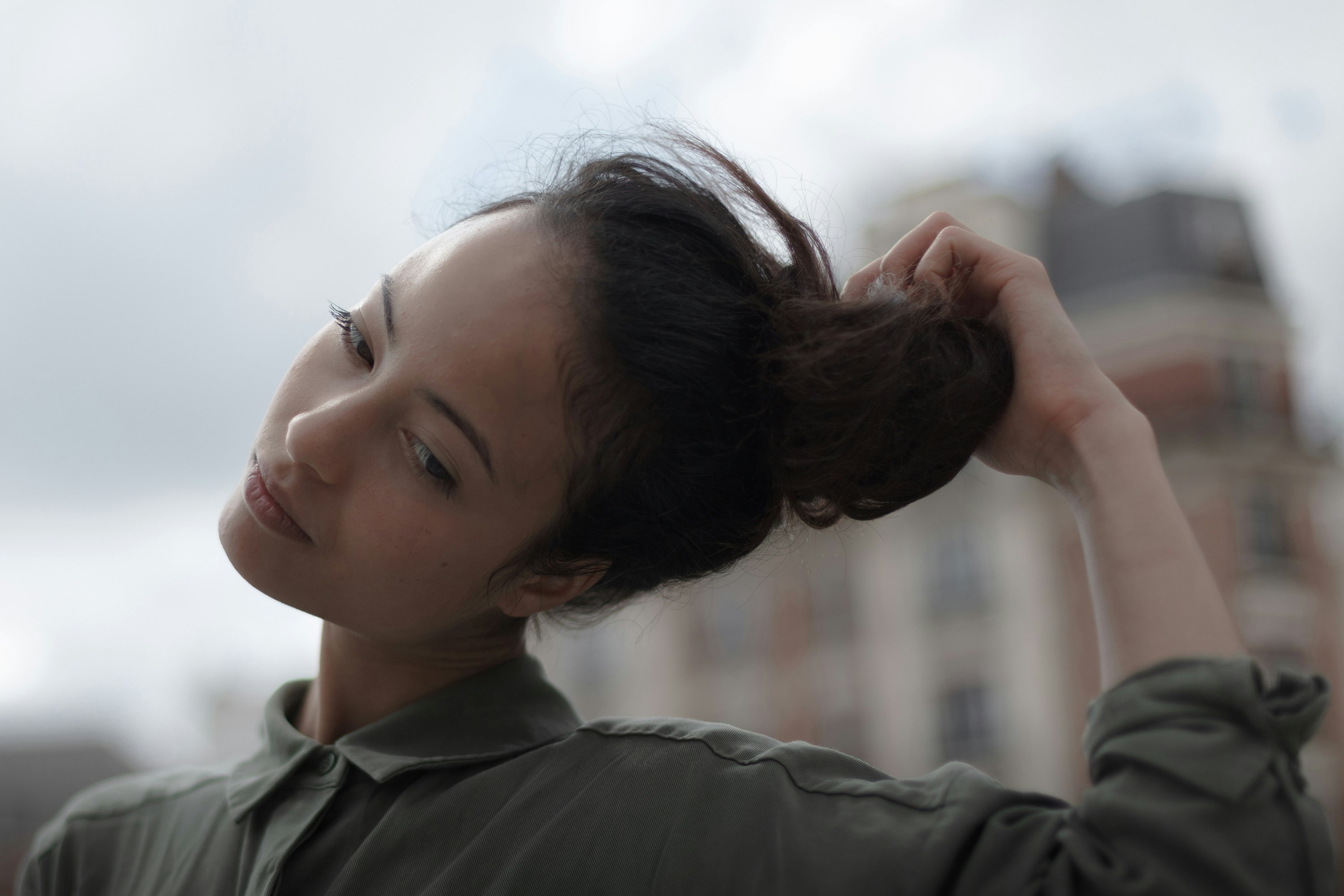 selective focus photography of woman holding her hair