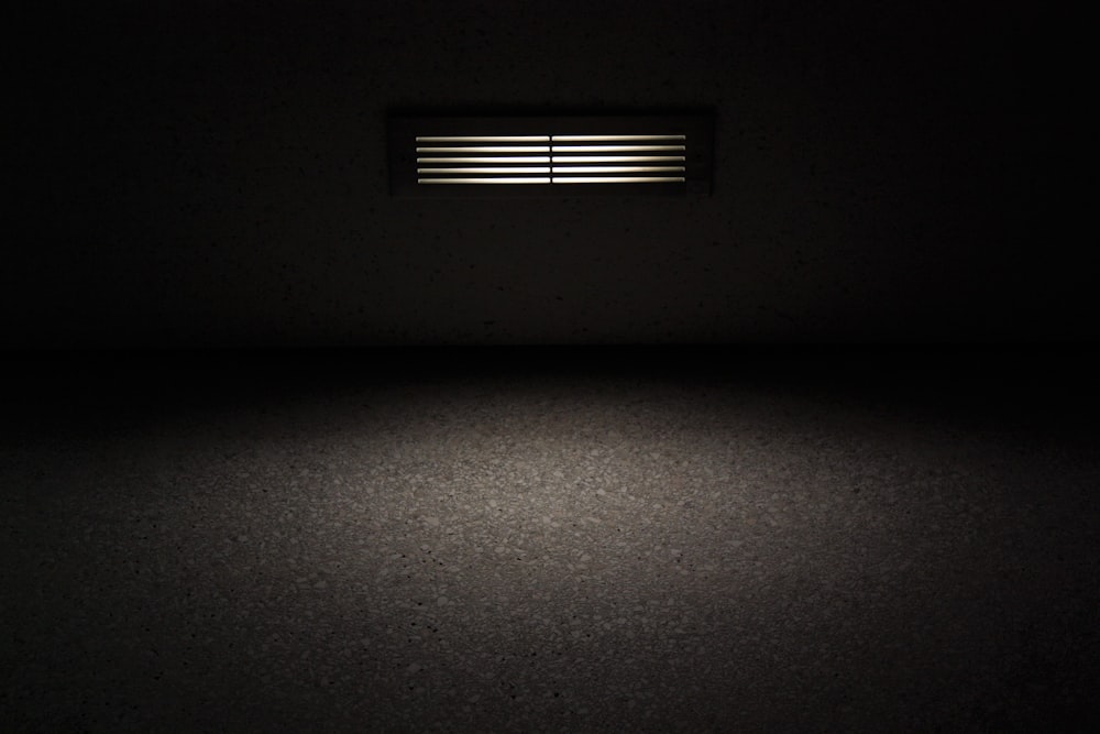 a dark room with a light coming from the ceiling