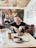 Happy man eating a breakfast sandwich with coffee in a bright modern fast food restaurant