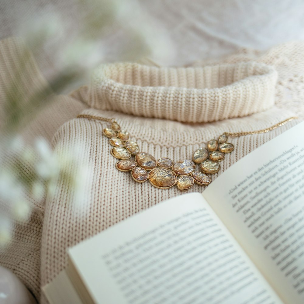 brown gemstone encrusted gold-colored accessory near open book