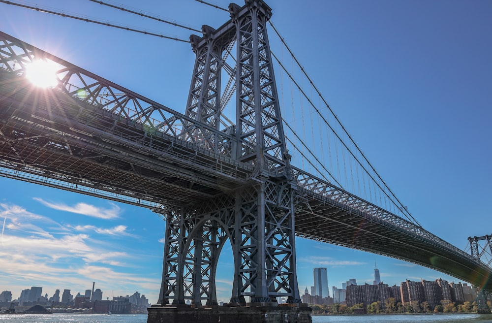 low-angle photography of gray metal bridge under clear blue sky