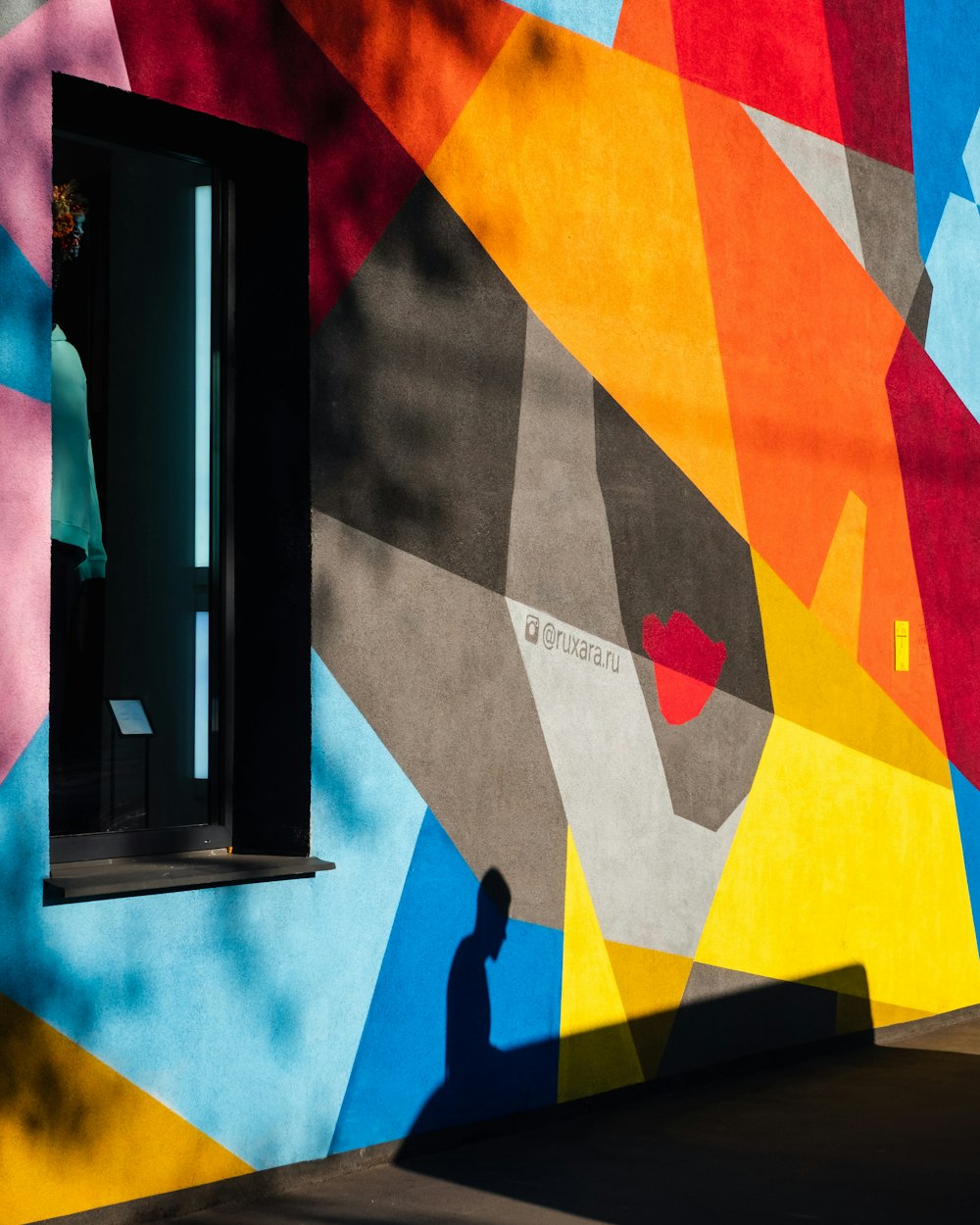 a person standing in front of a colorful wall