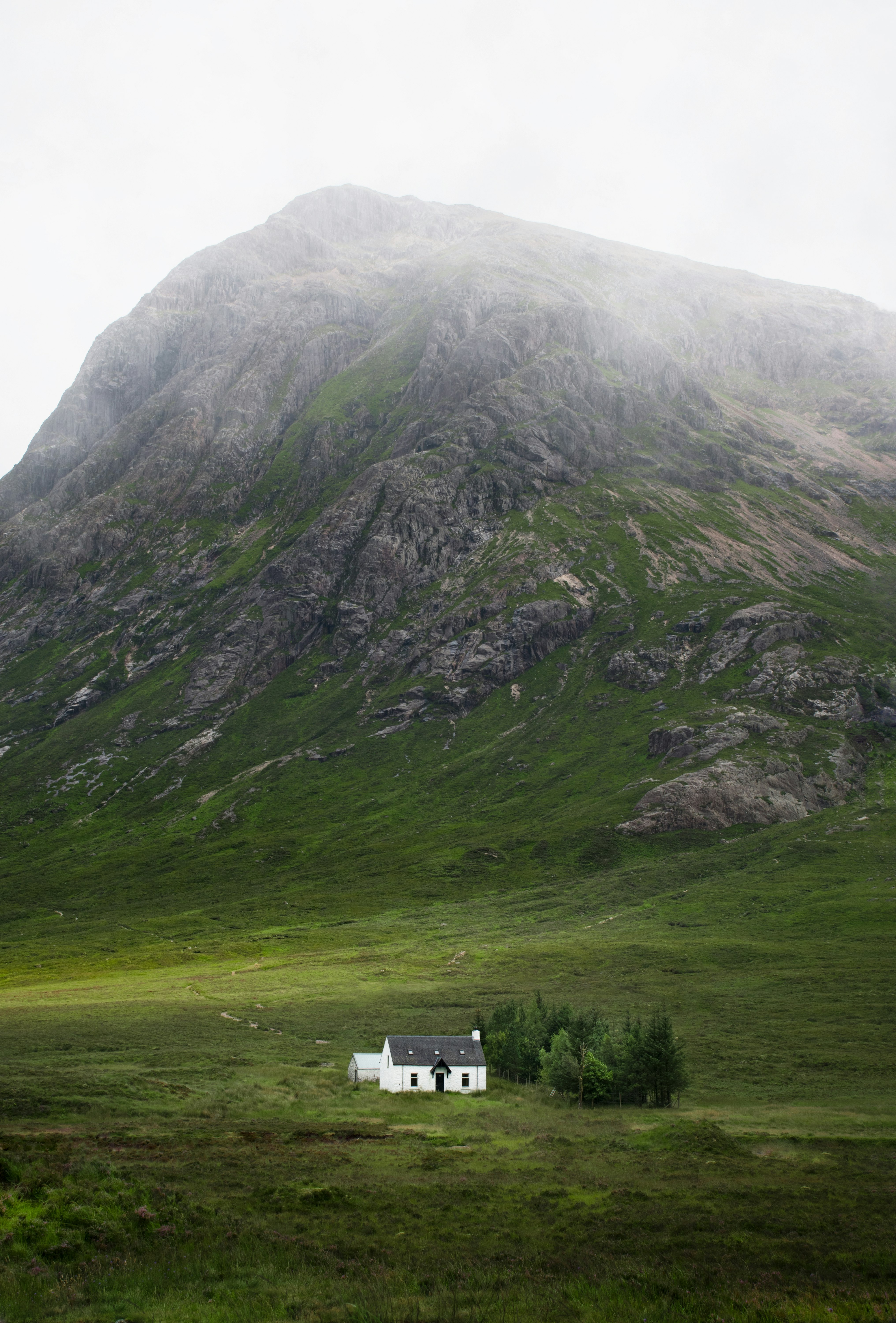 white and gray concrete house beside gray mountain