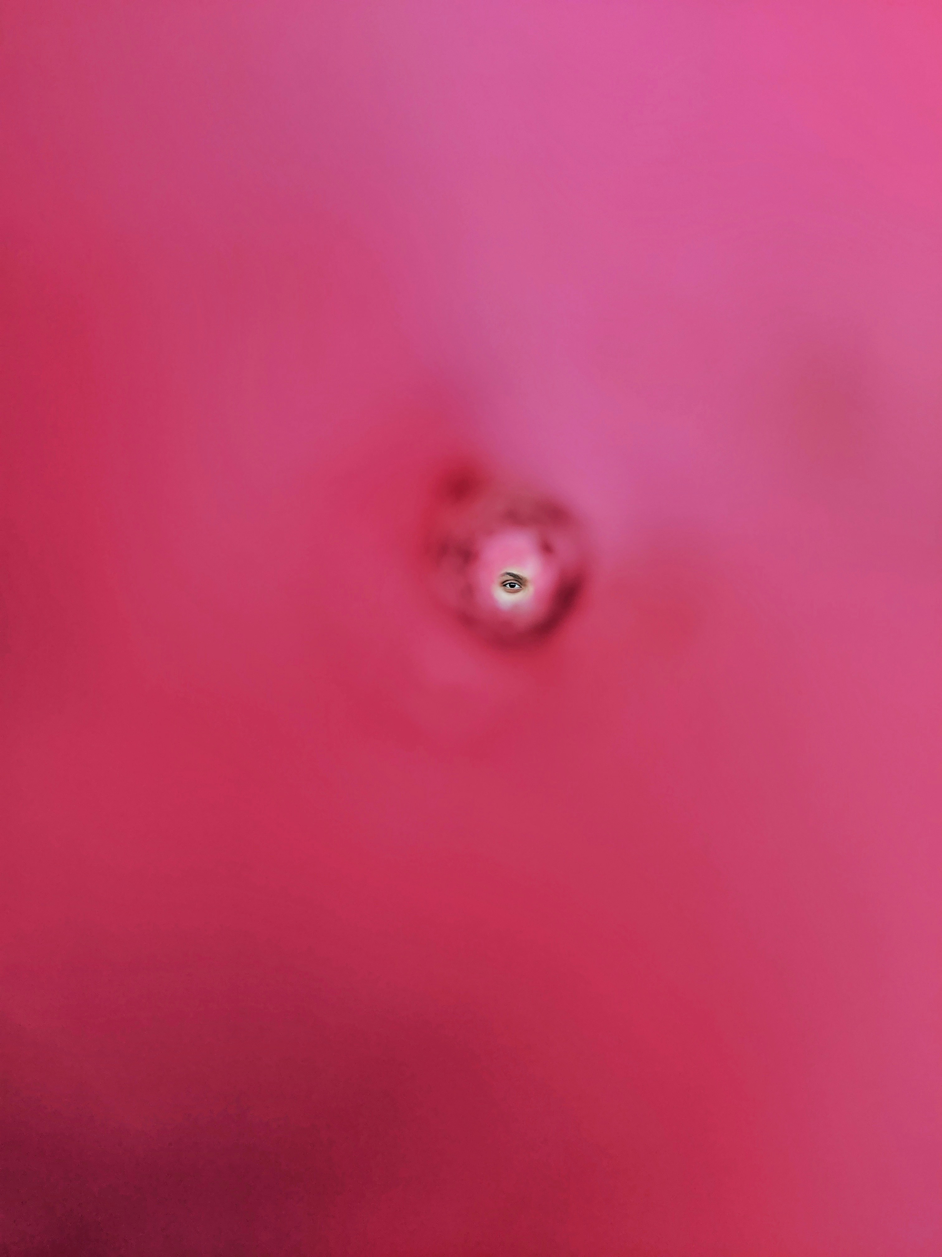 un fond rose avec un œil vert au centre