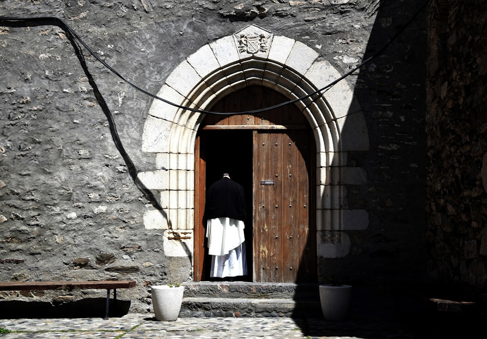 person standing beside wooden doors