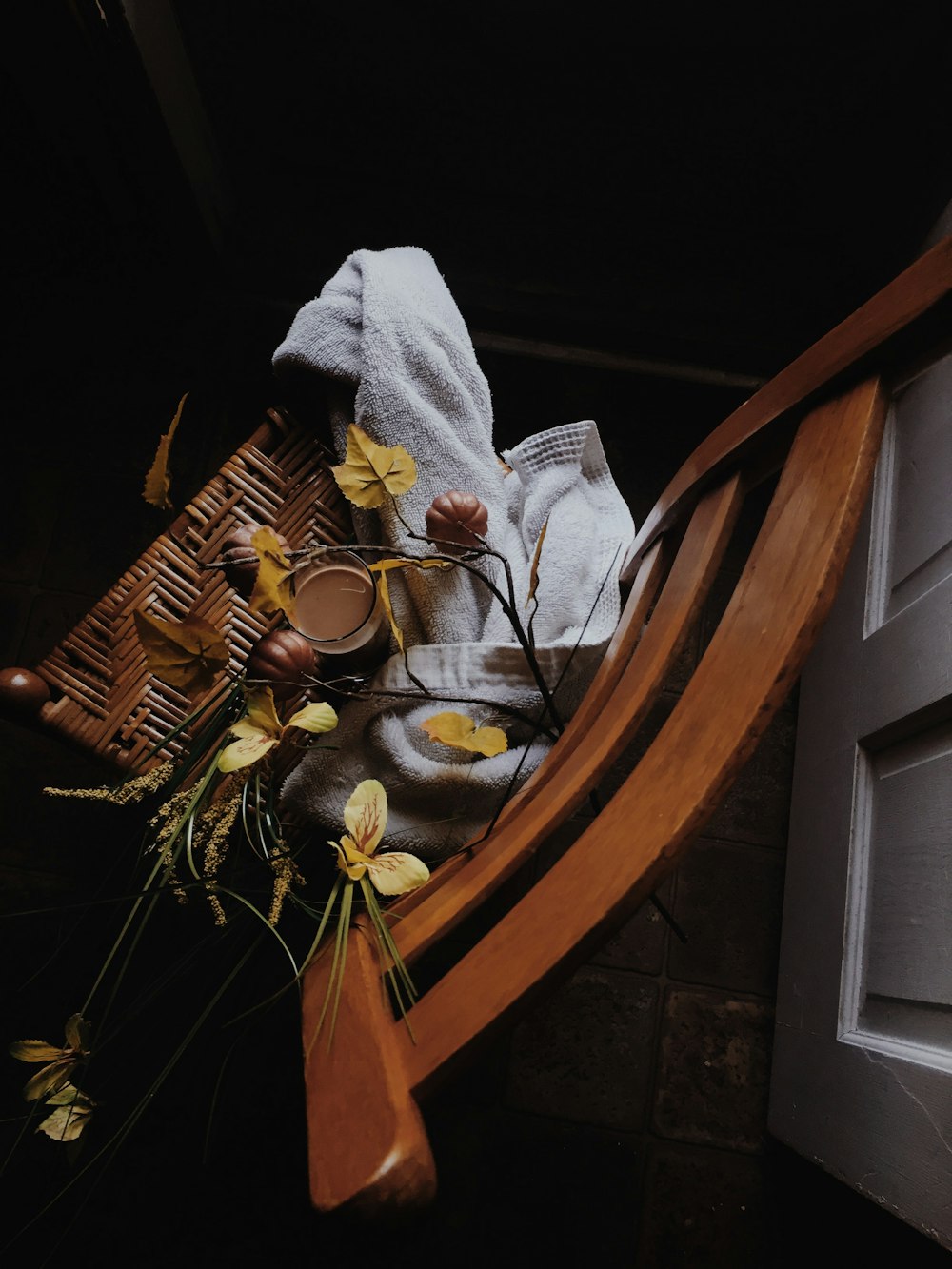 white towel and artificial plants on wicker chair