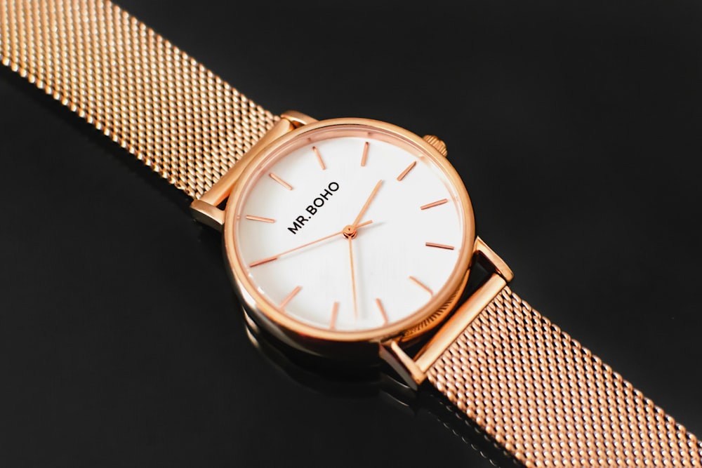 round gold-colored analog watch