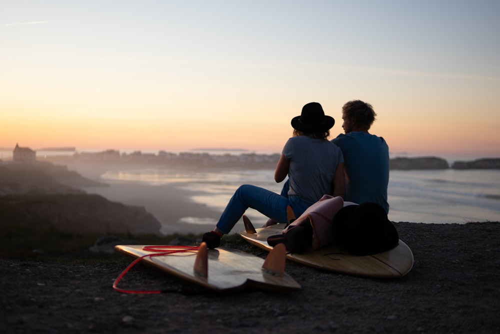 two person sitting on skimboard