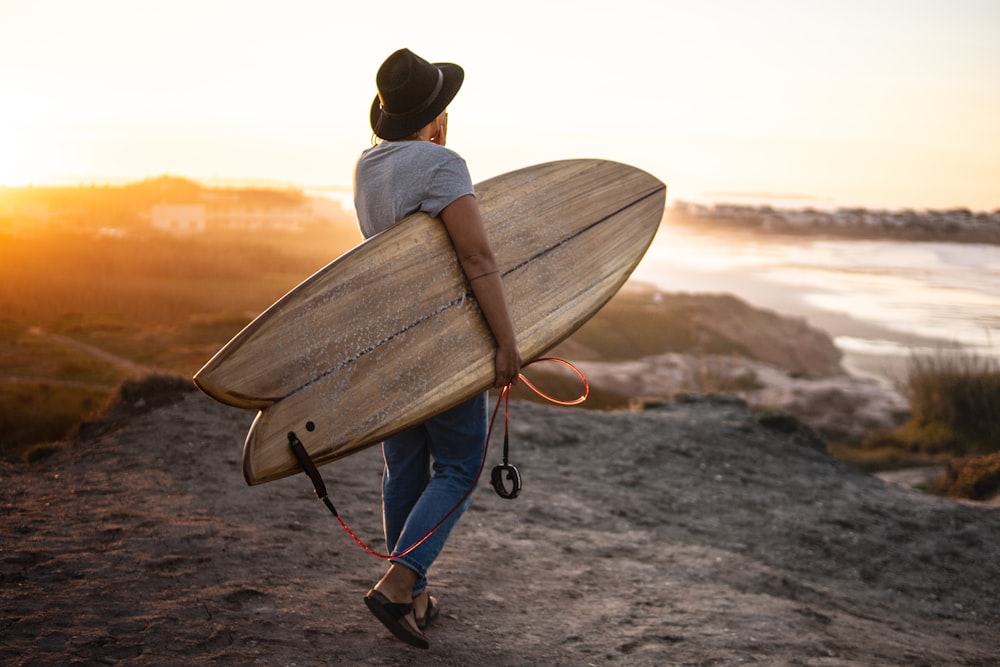 man holding brown surfboard