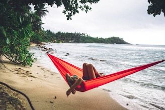 woman lying on red hammock
