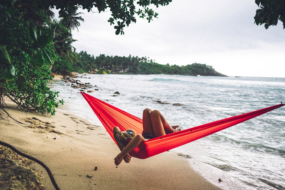 woman lying on red hammock