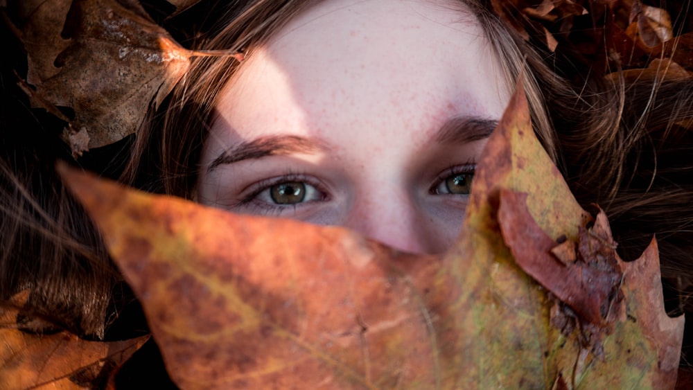 woman covered her face with dried leaf