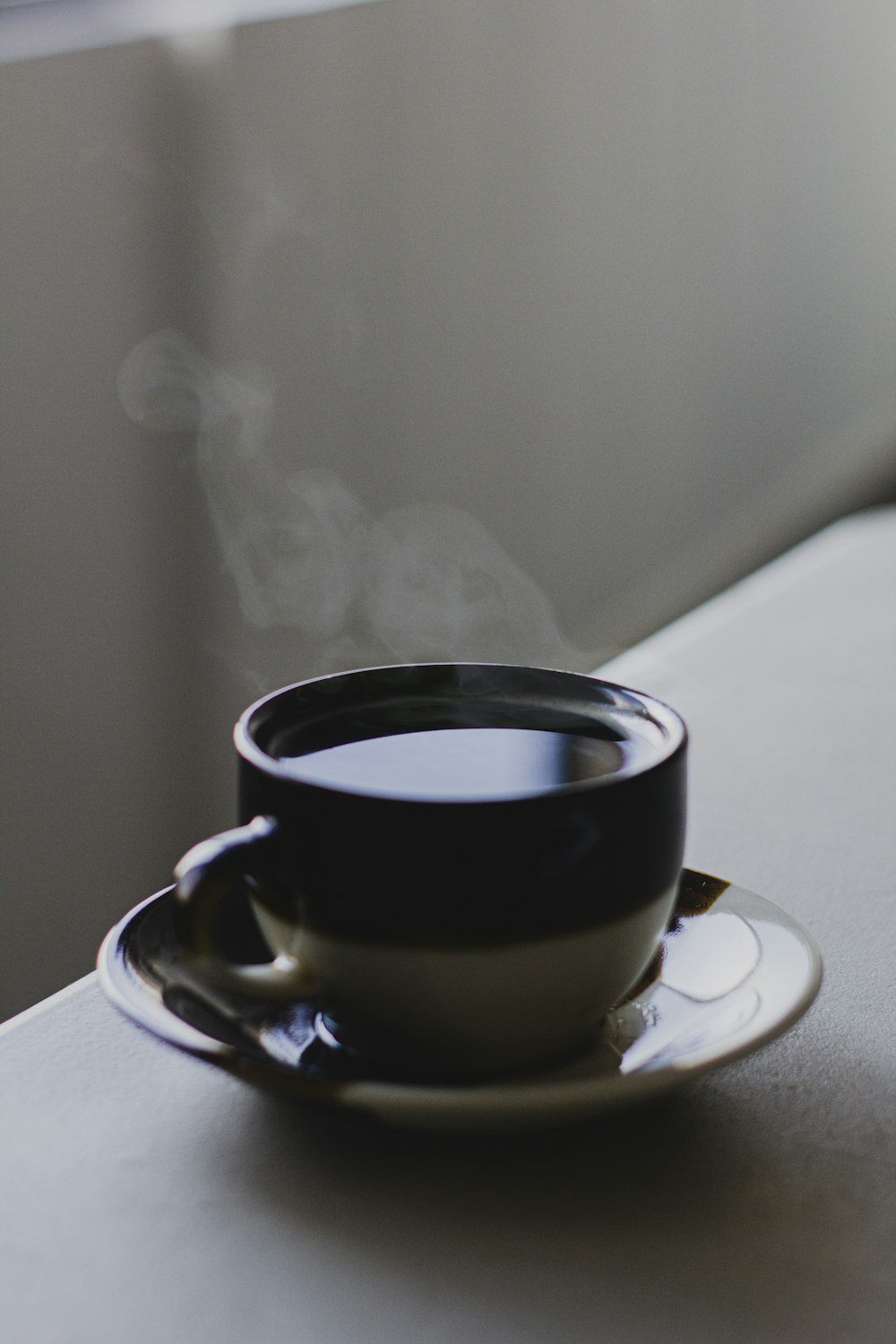 black ceramic mug with brown and white ceramic saucer