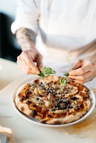 A chef's hands arranging a final garnish on a homemade meal before delivery.