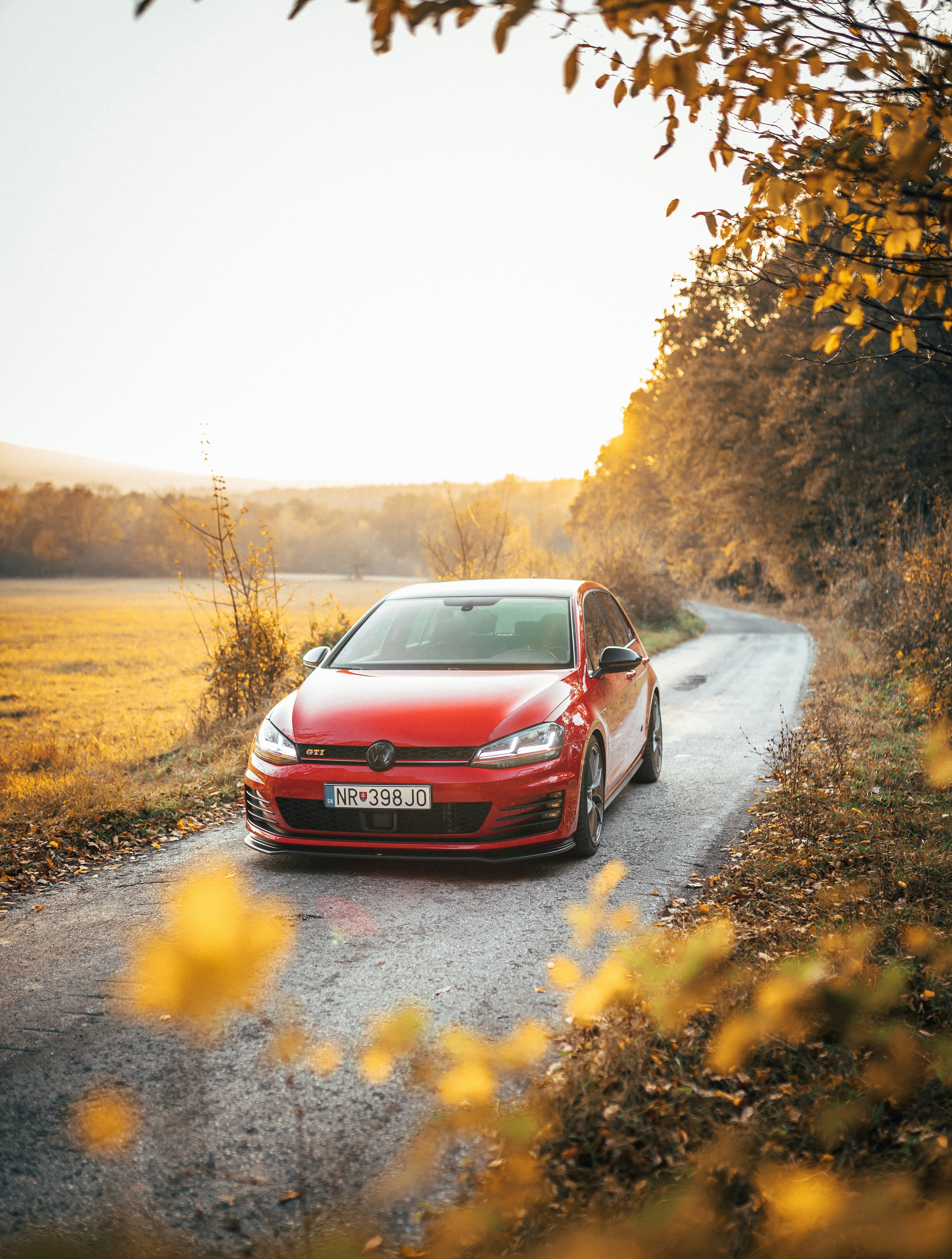 red car passing by a narrow road