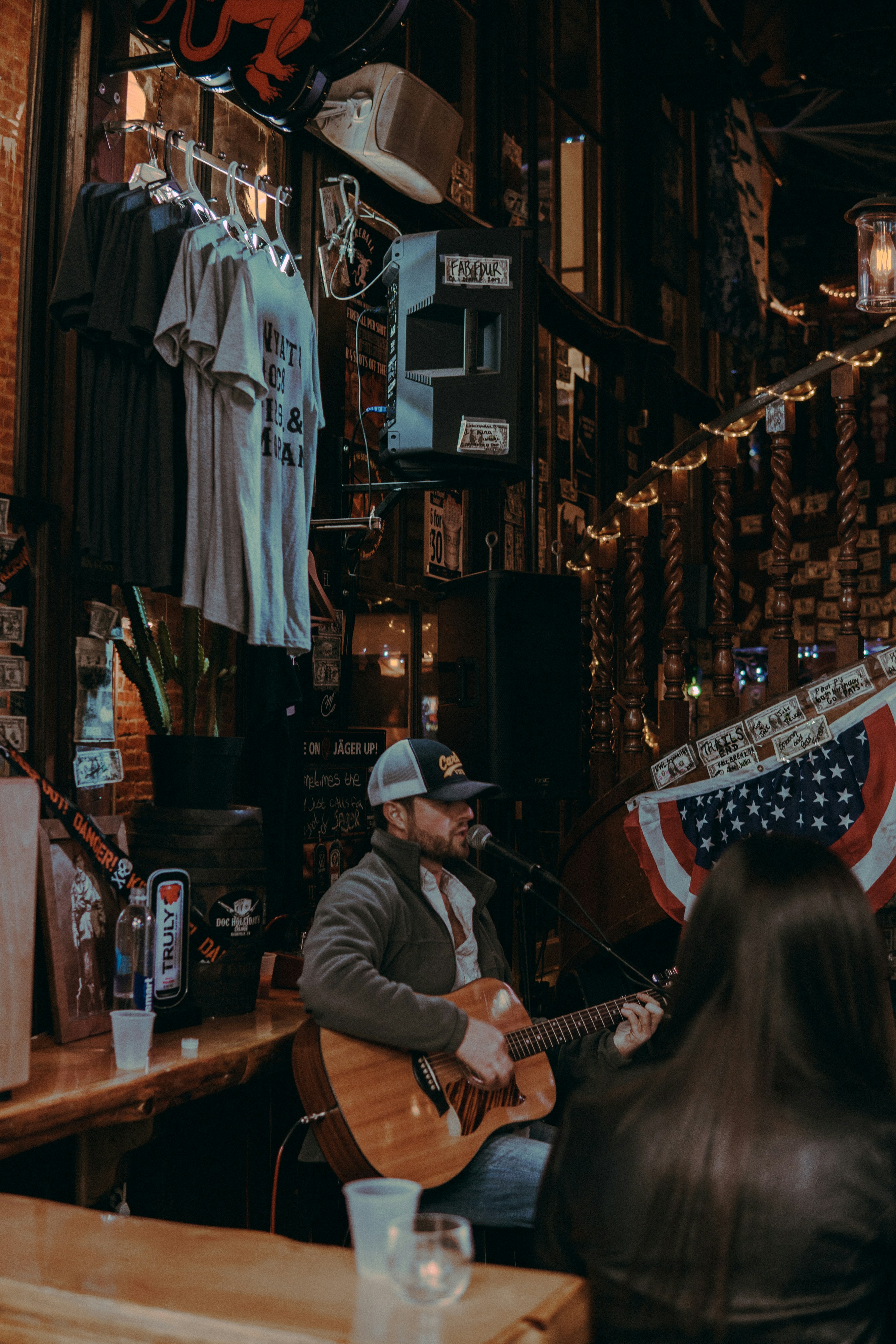 man in white and black cap playing brown guitar inside building
