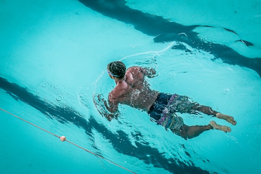 man swimming in pool