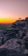 two person standing on cliff