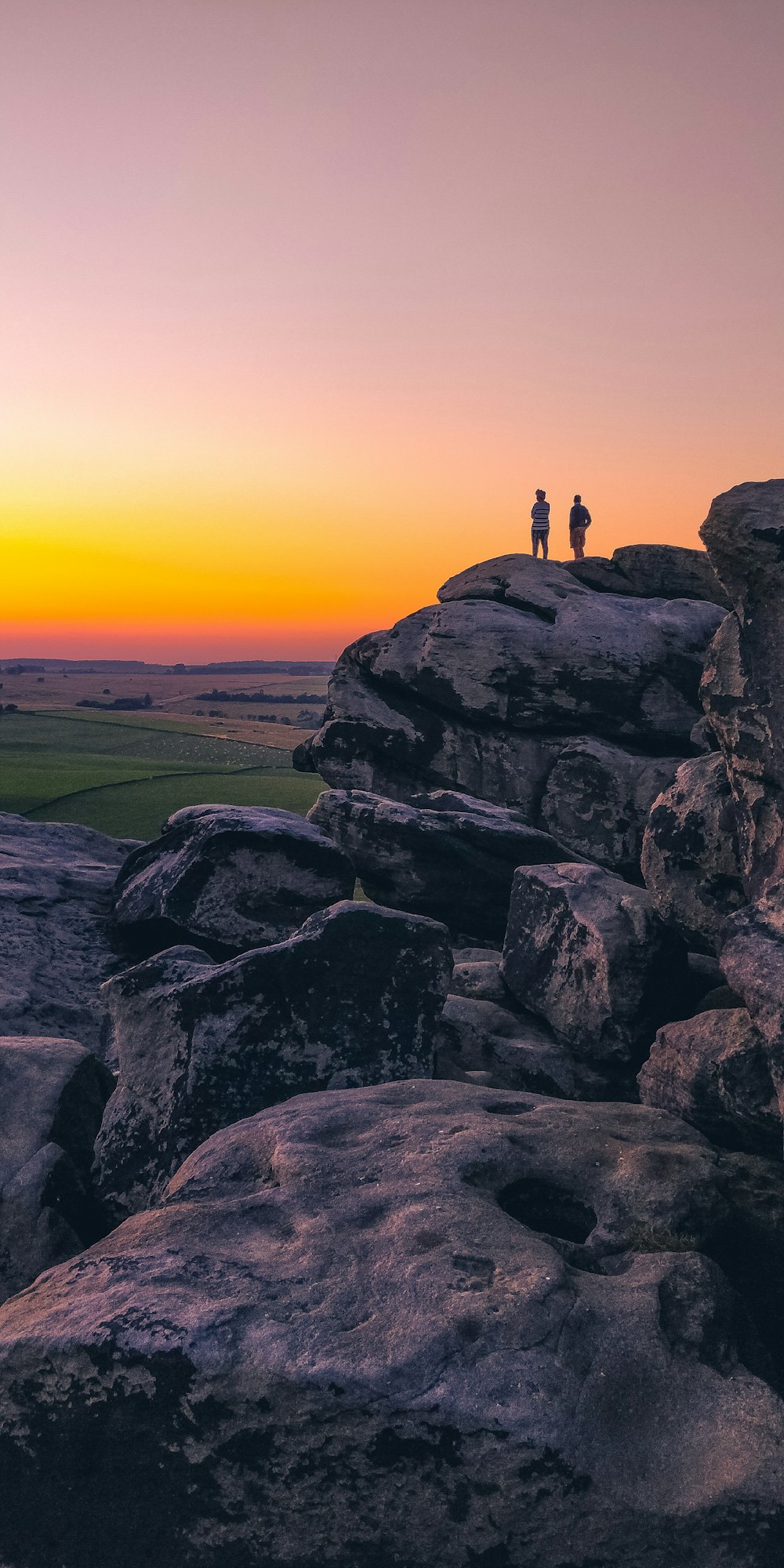 two person standing on cliff