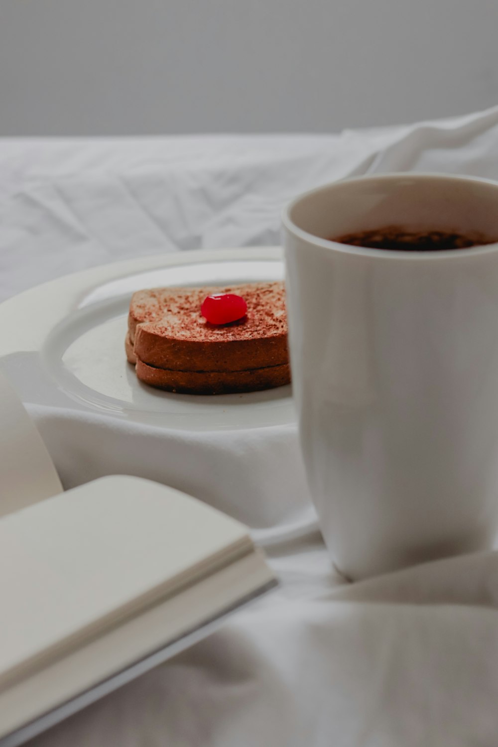 sandwich beside mug of coffee and book