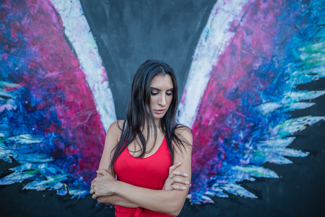 woman standing near painting of wings