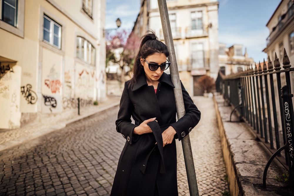 photo de mise au point superficielle d’une femme en trench-coat noir