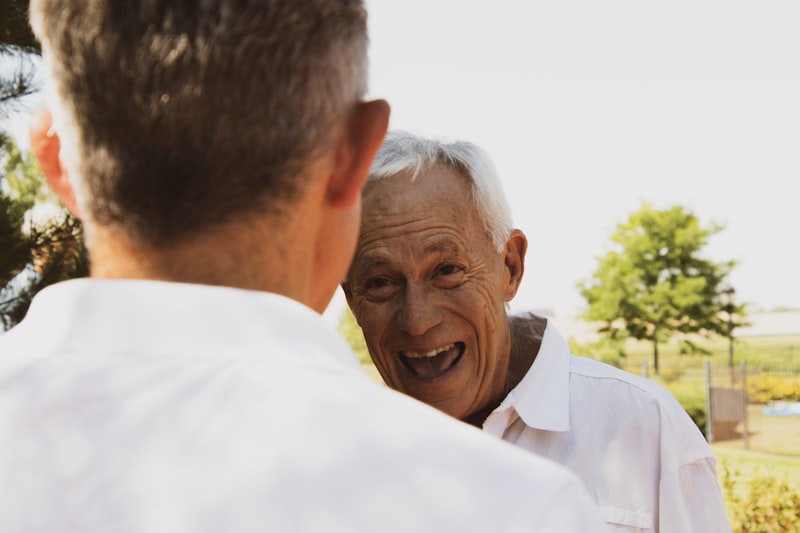 Senior caregiver sitting beside an older adult in a comfortable chair