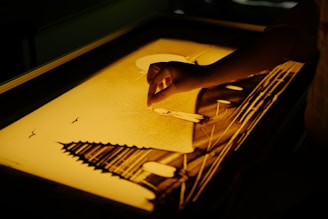 Close-up of hands gently shaping a colorful mandala sand art, symbolizing mindfulness.