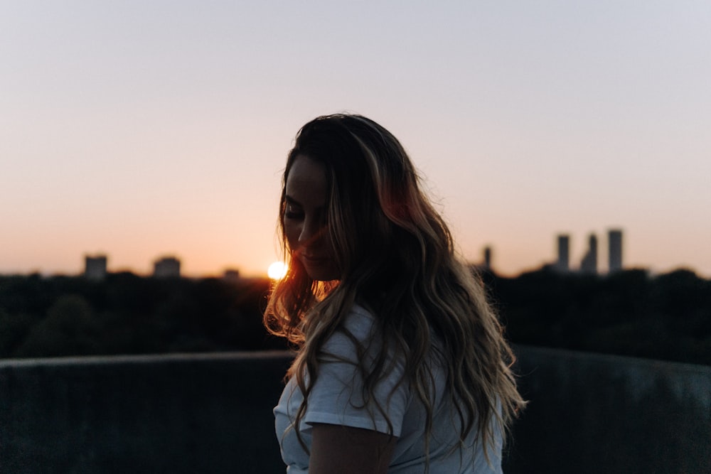 woman wearing white crew-neck t-shirt standing while glancing her left side