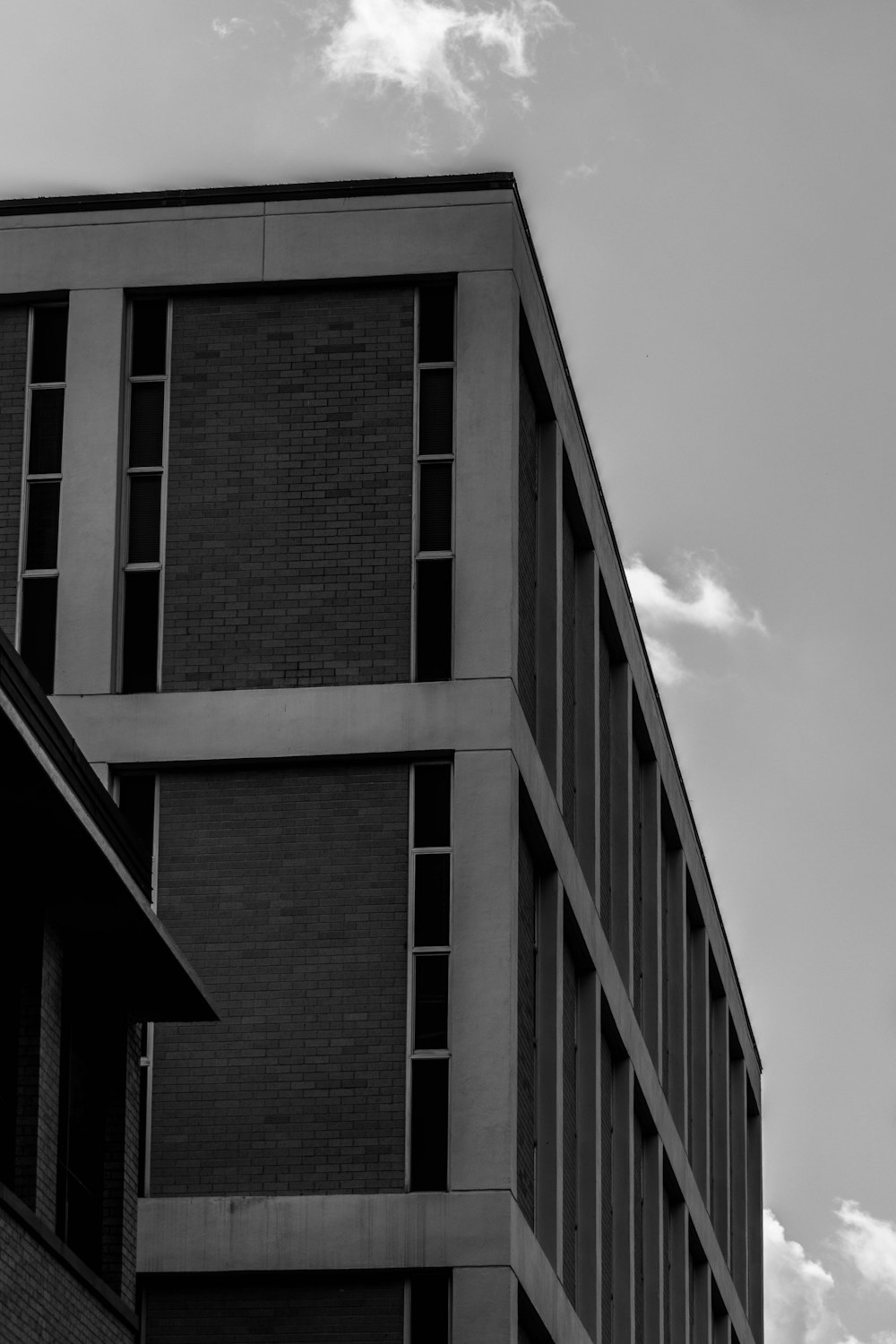 grayscale photo of building under cloudy sky