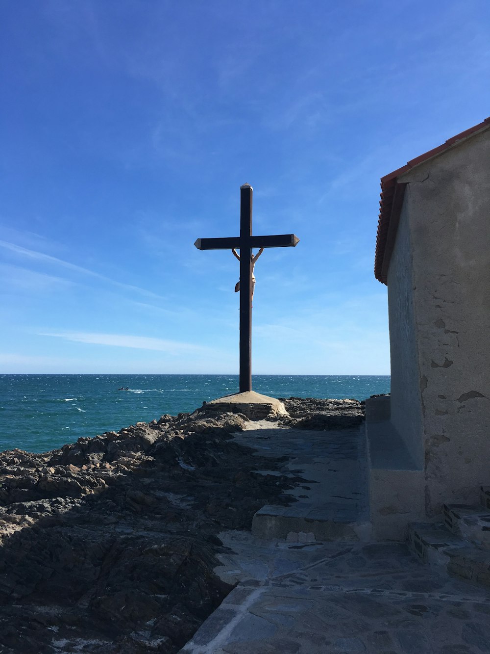 Cruz de madera marrón cerca del océano