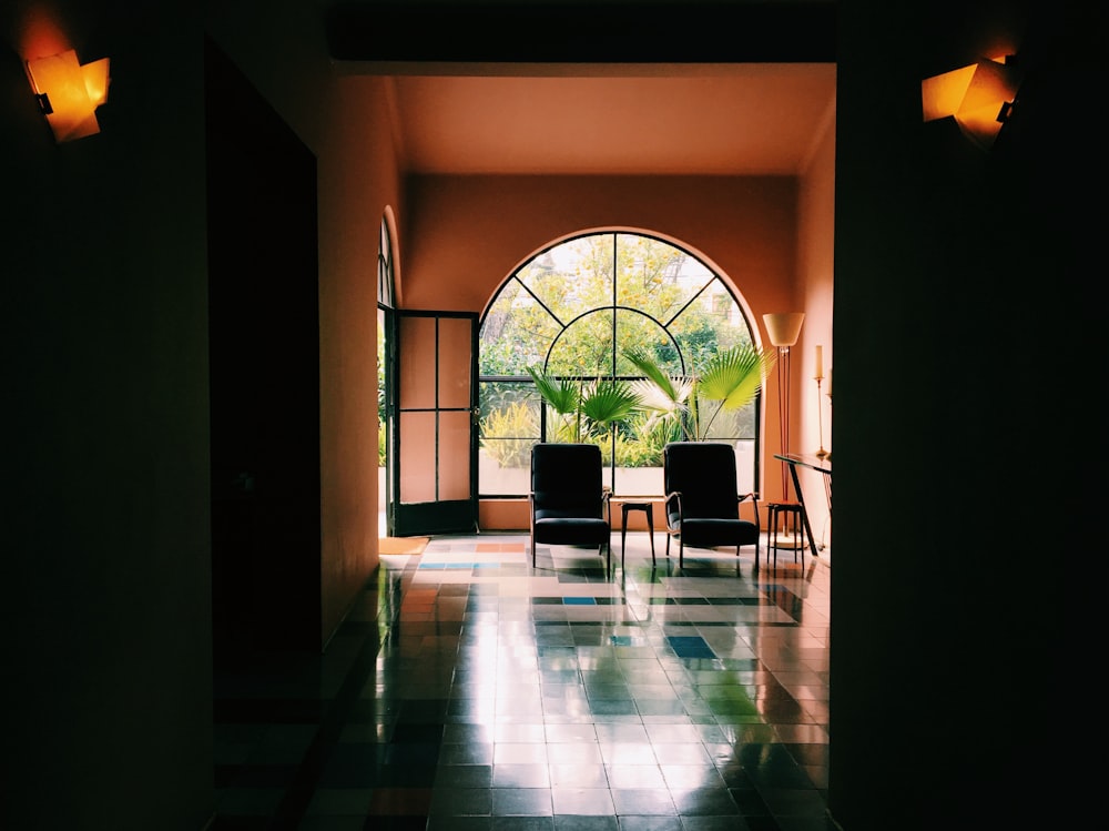 two empty black chairs beside glass wall