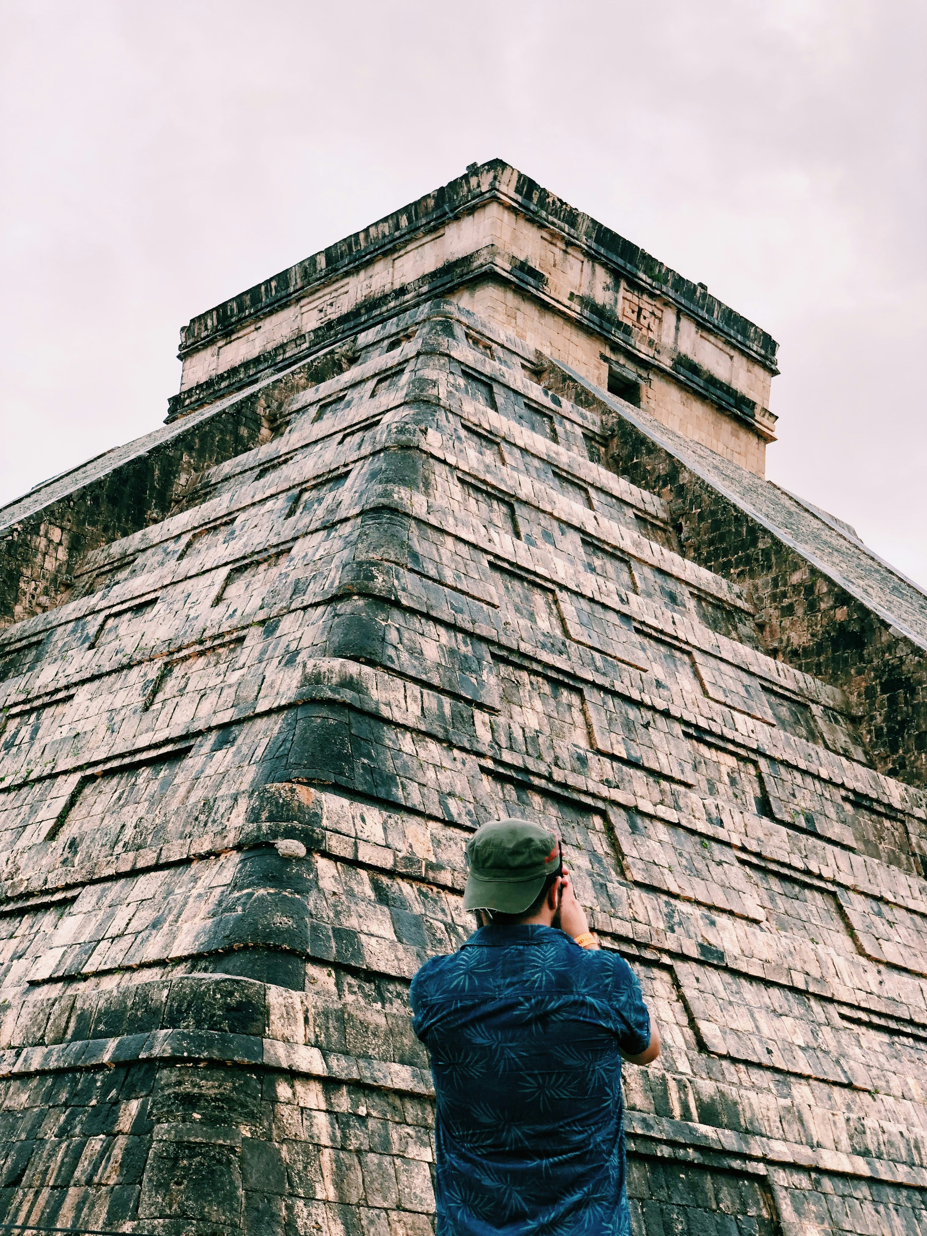 man standing brown stone building