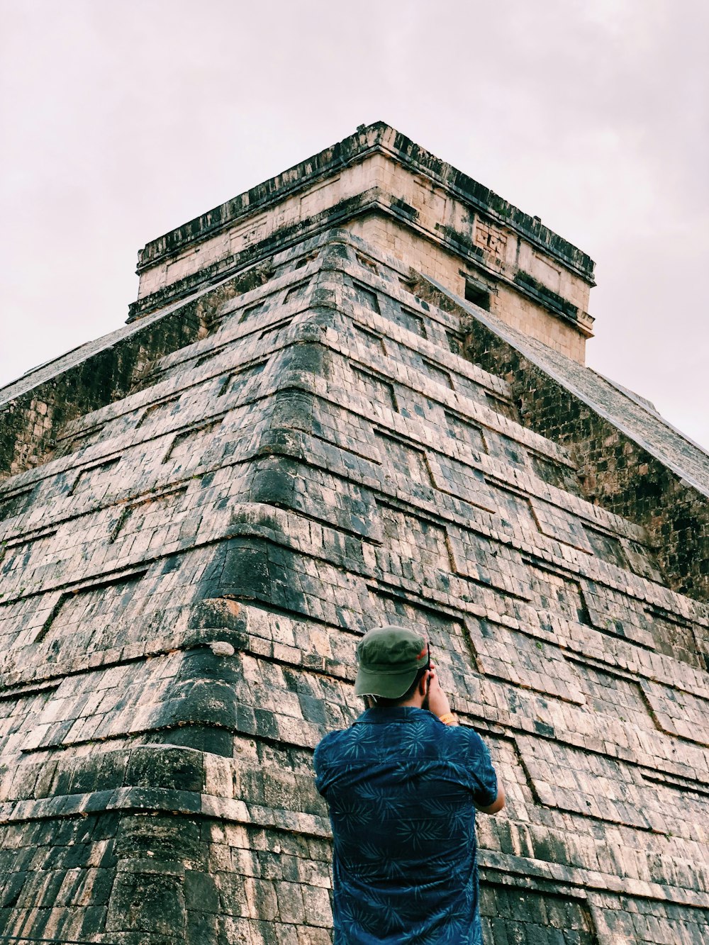 man standing brown stone building