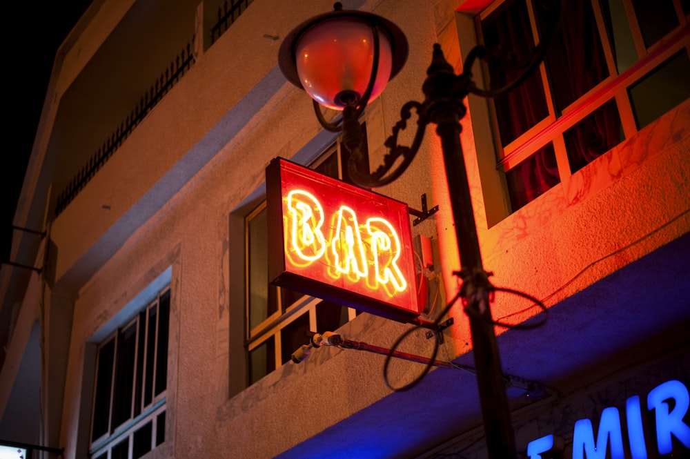 letrero de neón de bar rojo encendido por la noche