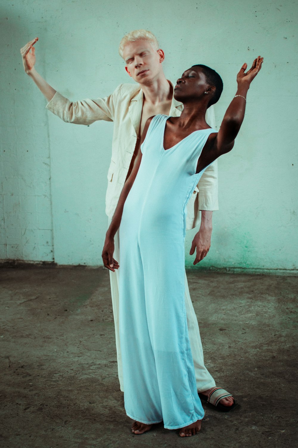 woman in white sleeveless dress behind man in beige dress shirt