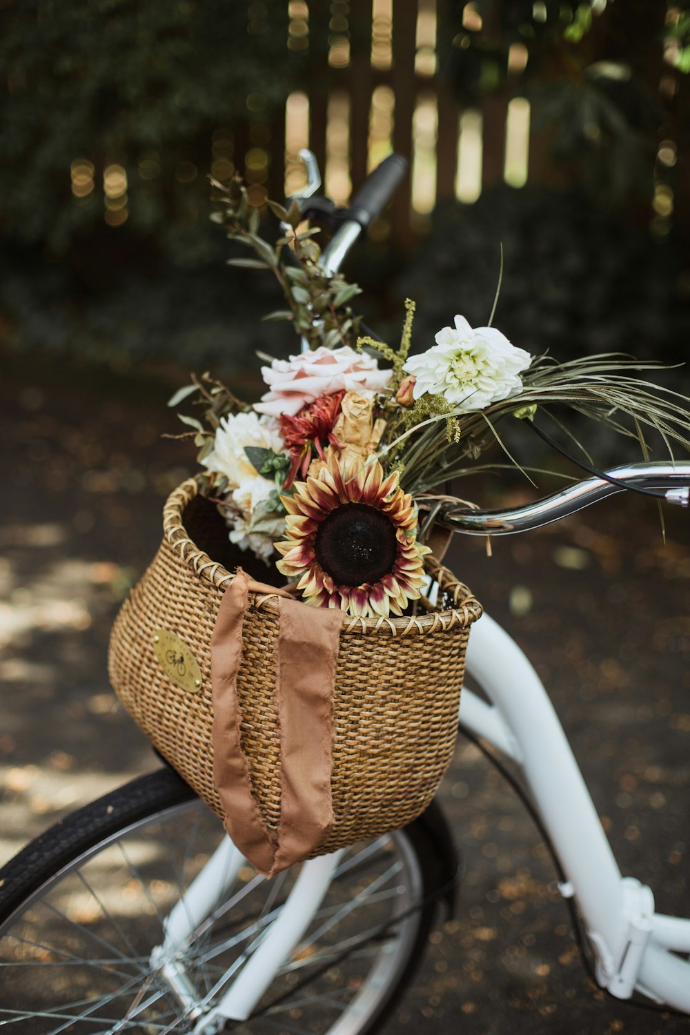 assorted flowers on a brown bike basket