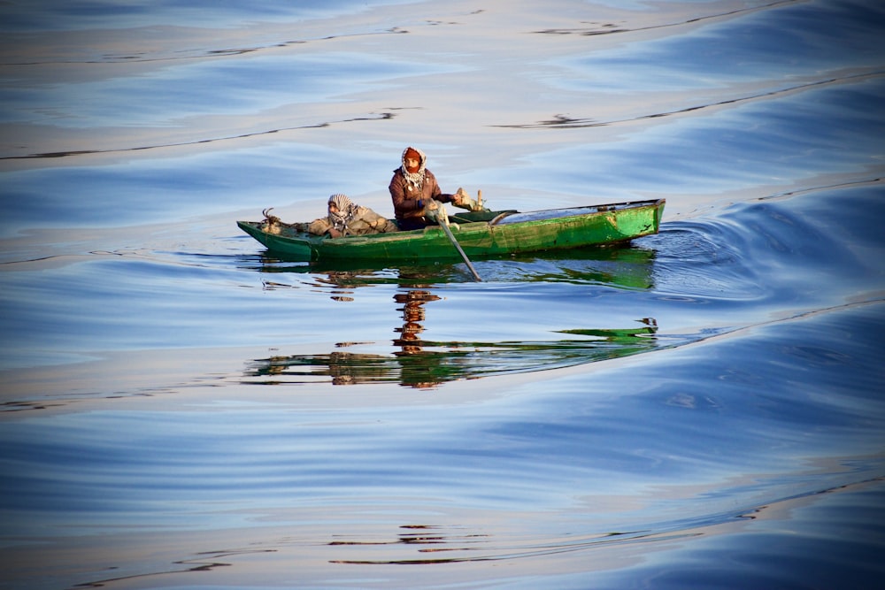 personne à bord d’un bateau vert