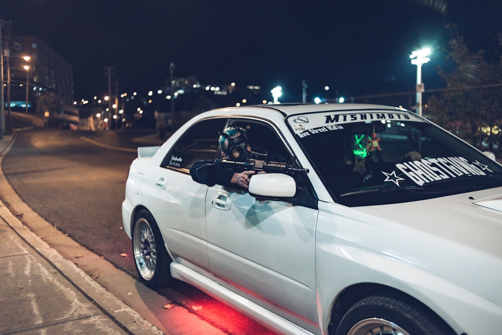 white sedan on roadway during nighttime