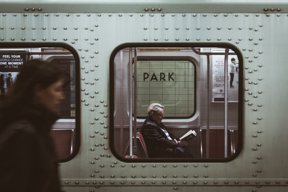 Mujer de pie junto al tren gris