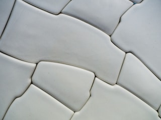 Close-up of a smooth, abstract 3D texture in soft gray and charcoal.