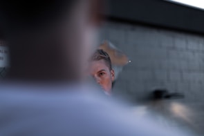 Close-up of a cracked mirror reflecting a blurred, ghostly face.