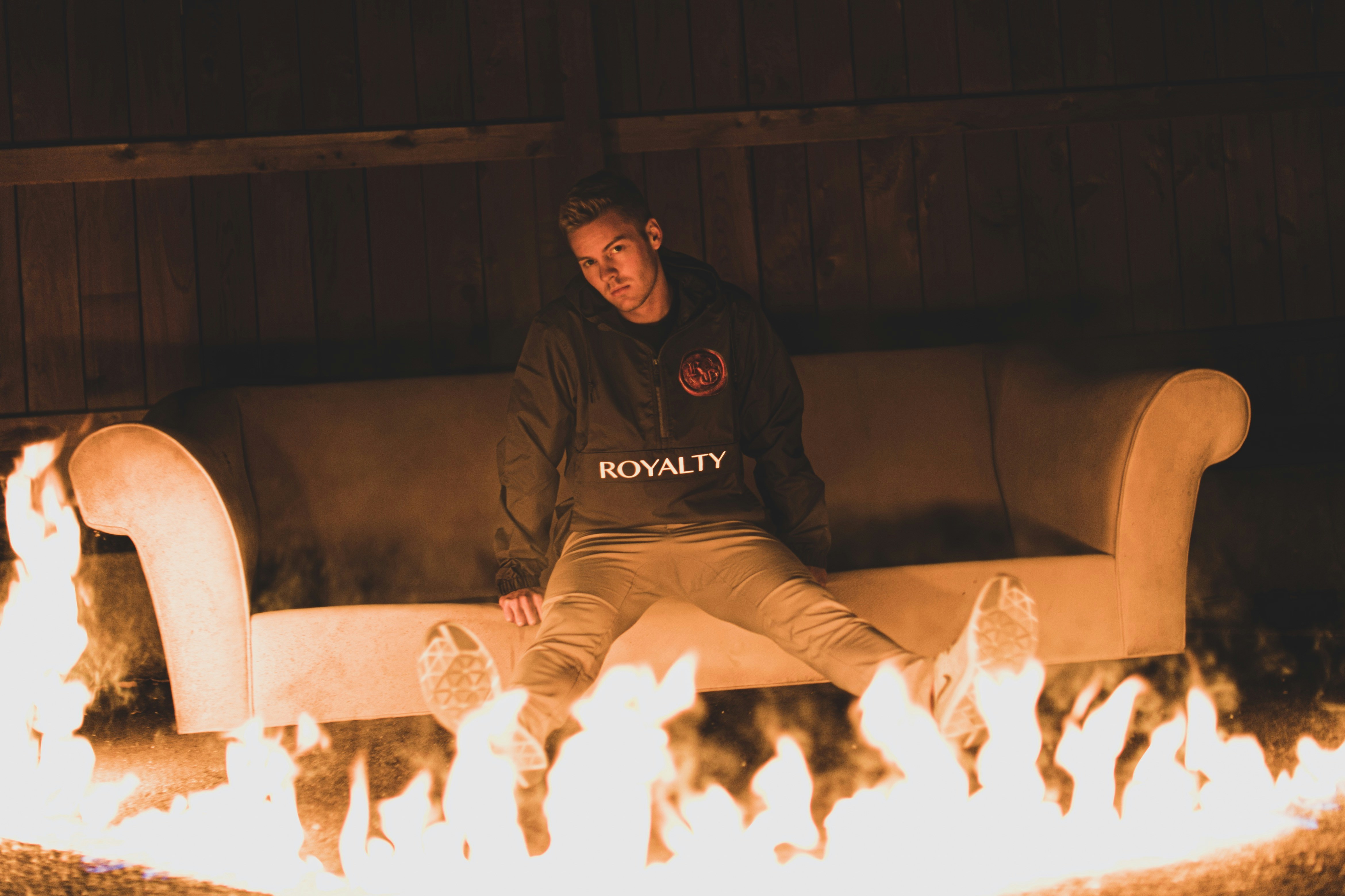 man in black hoodie sitting on white sofa
