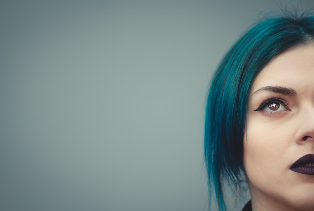 Una mujer con cabello azul y lápiz labial negro