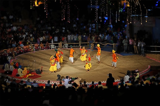 Colorful traditional dance performance in an open-air cultural festival setting.