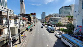 Busy street in Ambato showing buses and cyclists navigating urban traffic.