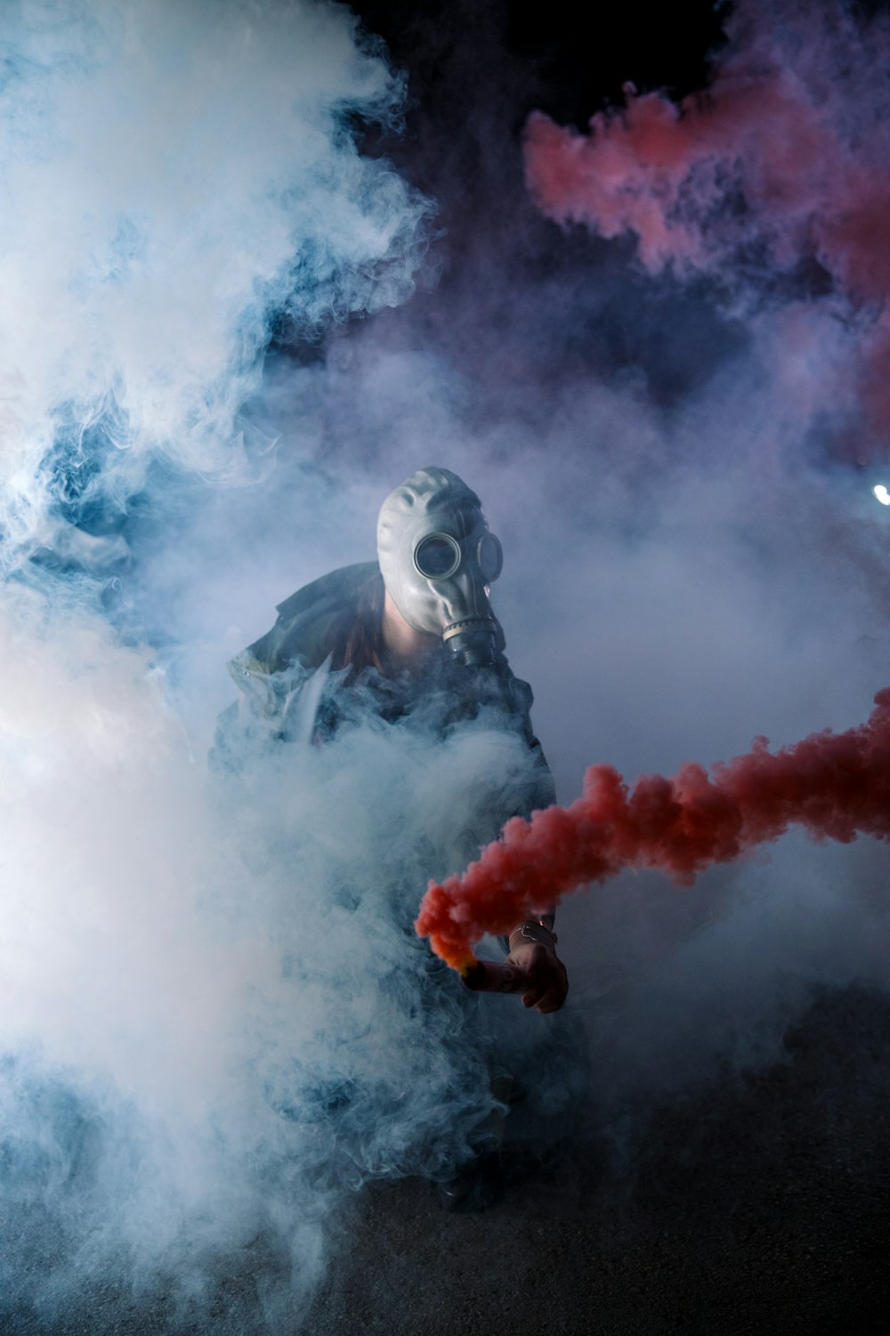 man with gray gas mask standing with gas smokes