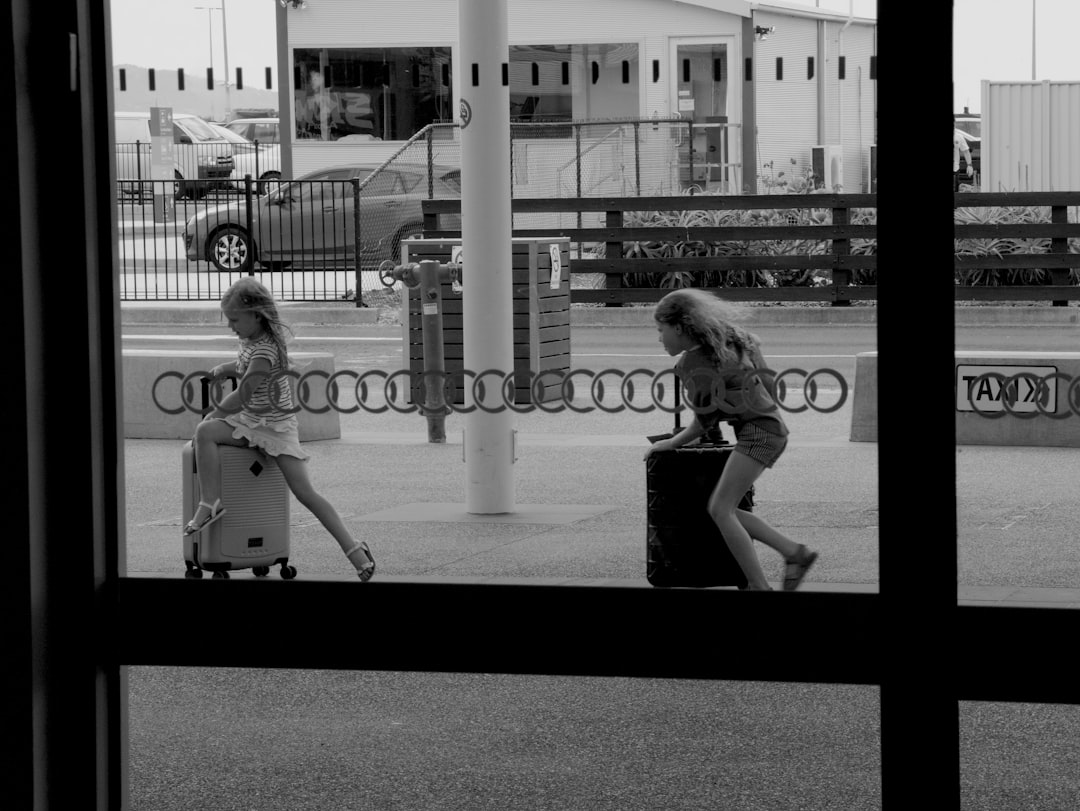 grayscale photography of two girls playing on stroillers