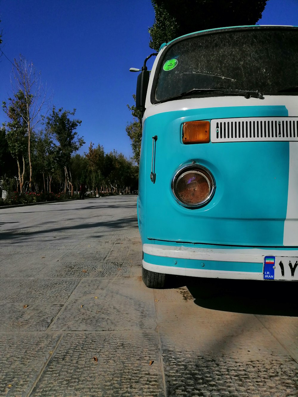 parked white and teal bus during daytime