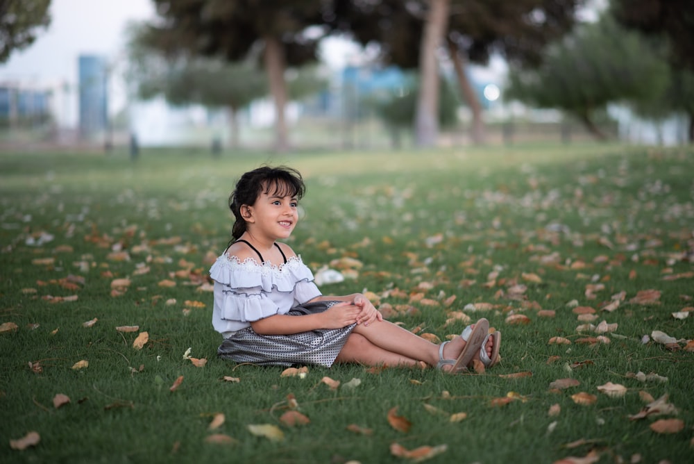 girl sitting at a grassy lawn